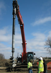 Long reach excavator installing screw piles with a Digga drive