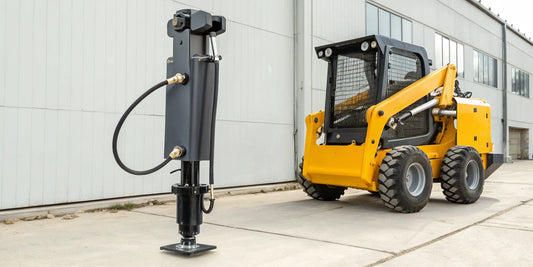 A hydraulic jack hammer attachment mounted on a skid steer.