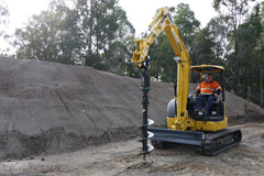 Excavator collaring a hole with a Digga auger drive